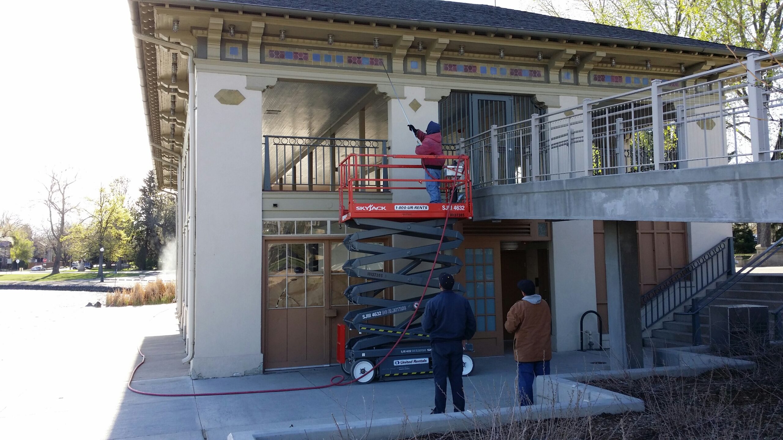 Cleaning the eaves of the Washington Park Boathouse in Denver, Colorado with air pressure