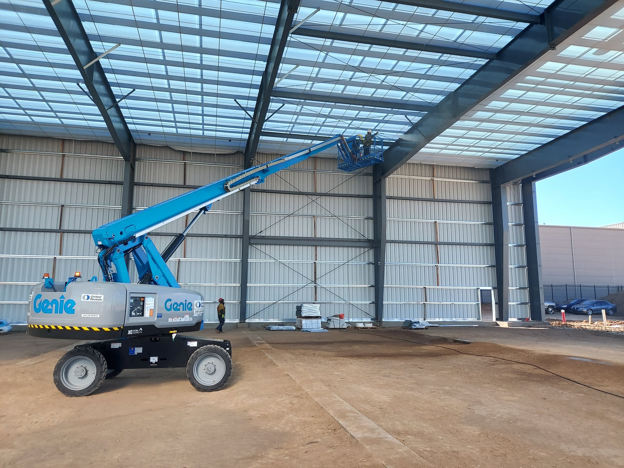 Using a boom lift to pressure wash an airport hanger in Centennial, Colorado