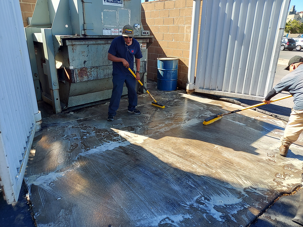 Applying Degreaser to a Dumpster Enclosure in Arvada Colorado